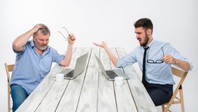 The two colleagues working together at office on white background The two colleagues working together at office on white background. both are looking at the computer screens. both very upset. concept of negative emotions and bad news
